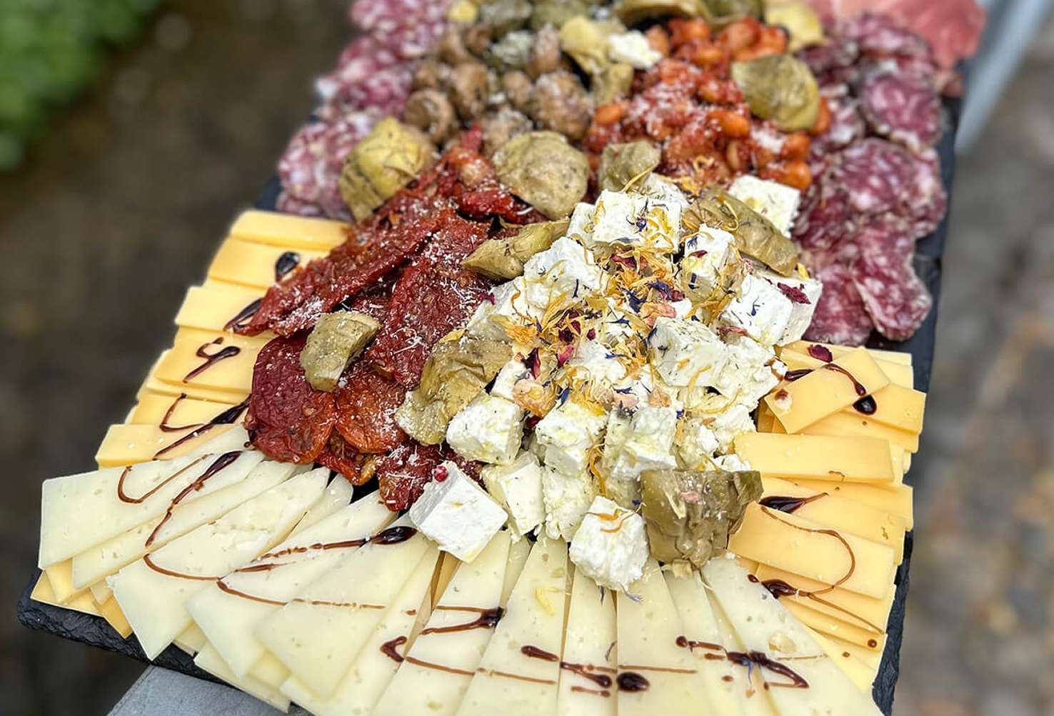 Längliche Cateringplatte mit Käse, Salami, mariniertem Käse und Antipasti