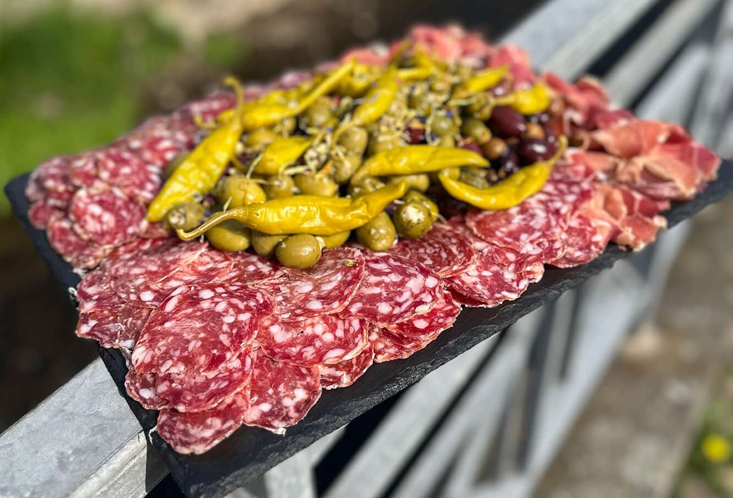 Salamiplatte mit Schinken, grünen und dunklen Oliven sowie Peperoni