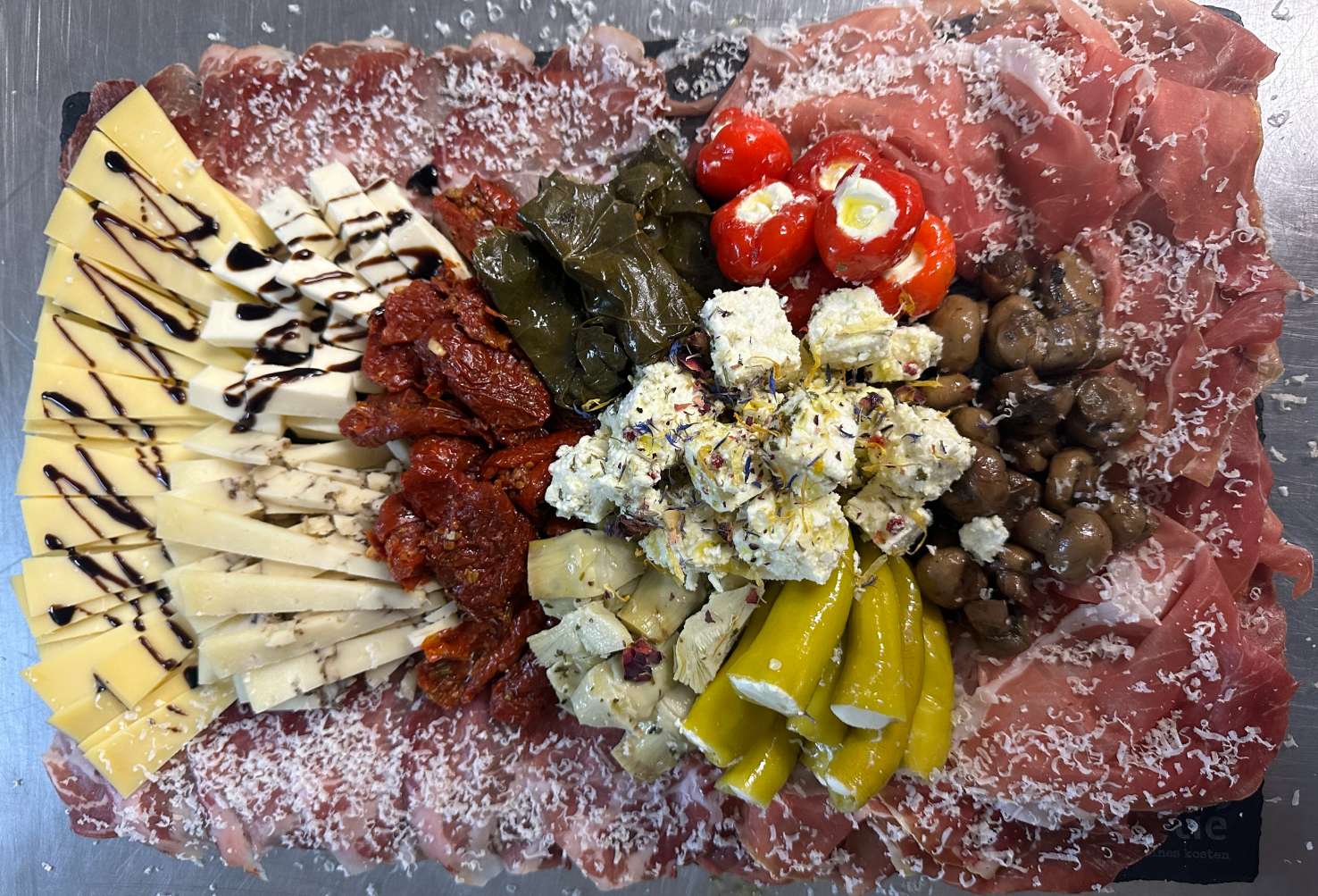 Cateringplatte mit Schinken, Käse, Oliven, gefüllten Weinblättern und Paprika
