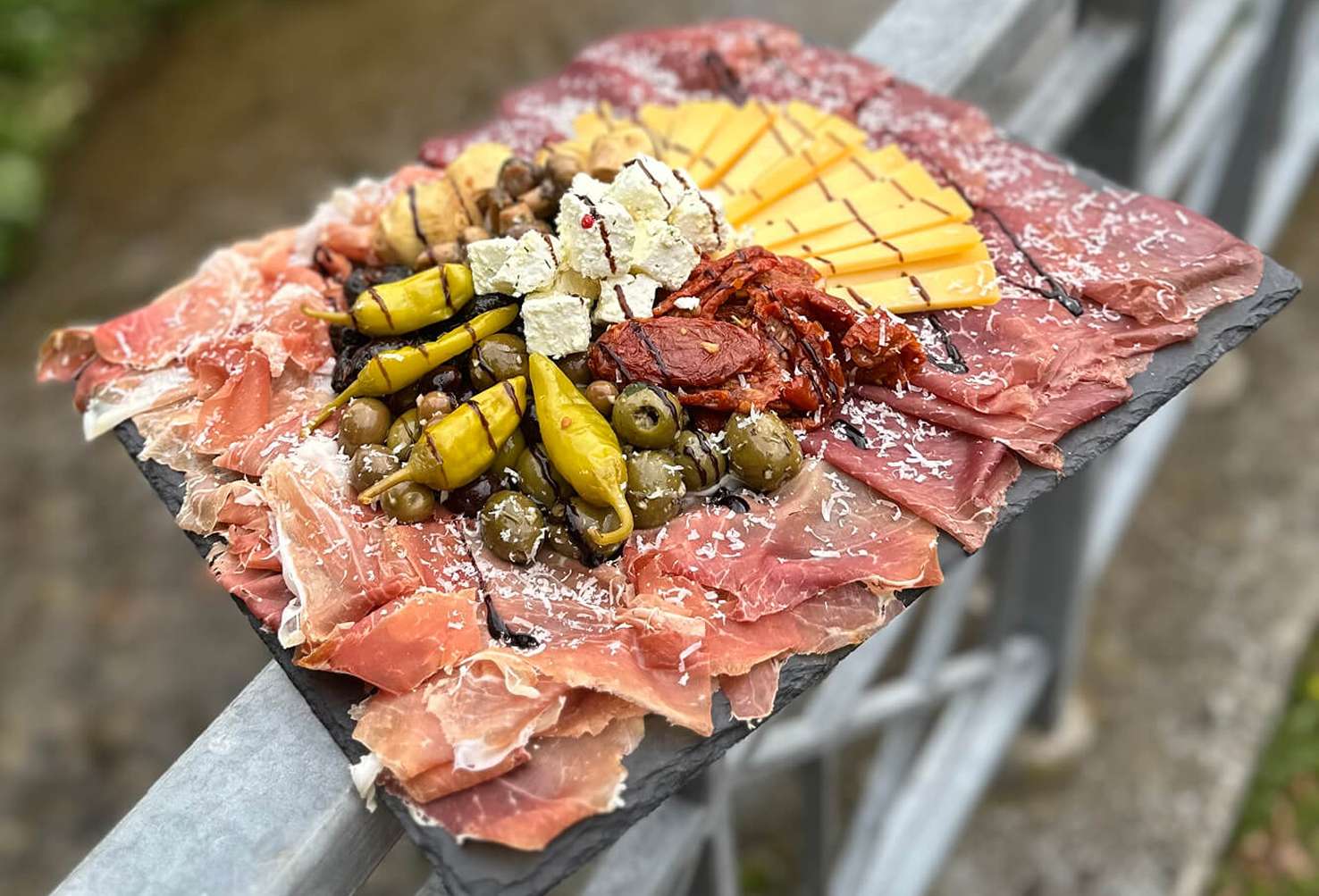Cateringplatte mit Schinken, Salami, Käse, Oliven und gegrilltem Gemüse